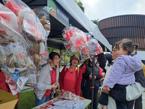 游客於报佳音市集摊位前选购商品