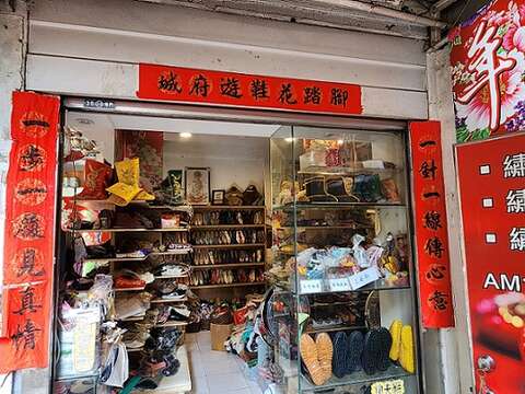 李东志缝鞋底时灵机一动，亲手写下门口对联「一步一履见真情」、「一针一线传心意」，横批「脚踏花鞋游府城」。（郑佩雯拍摄）