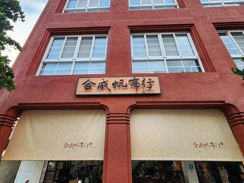 合成帆布行位於台南市中山路，赭红色四连栋街屋气派醒目，开放式店面经常吸引游客驻足。（郑佩雯拍摄）