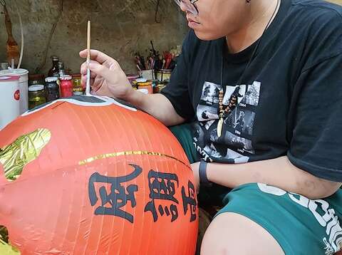 传统灯笼在形式色彩上有所规范，寺庙用灯通常会写上庙名或所祀神名，左右两侧加上国泰民安、风调雨顺等吉祥字句。（郑佩雯拍摄）