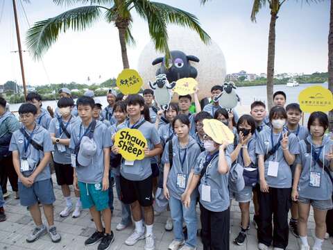 学子们与英国人气角色「笑笑羊」大型装置合影。