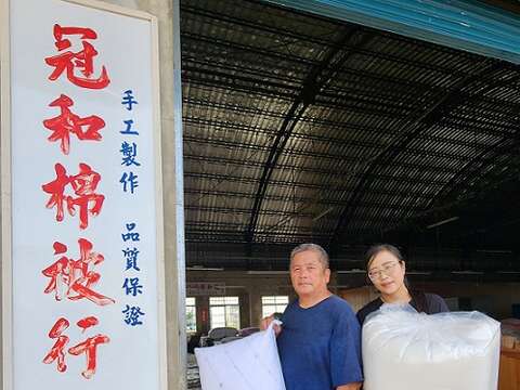 坚持传承手工制被职人精神与技艺的蔡顺龙（左）、蔡雯雅（右）父女。蔡顺龙手中是隐藏版木棉花枕头，Q弹紮实。（郑佩雯拍摄）