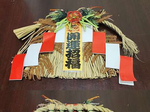 张淑娥强调日本各地习俗不同,注连绳型式和稻草编法都不一样。图为四国地区注连绳正反面,插脚角度和方向各有要求。(郑佩雯拍摄)