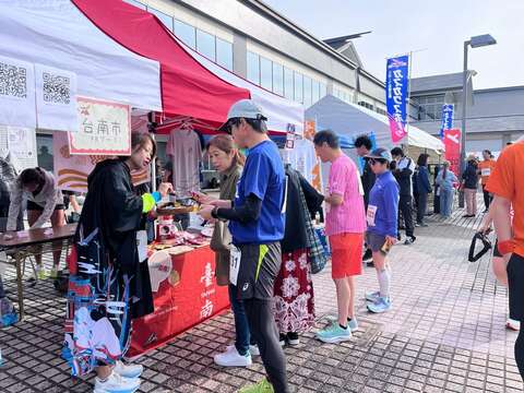 台南观光推广摊位提供特色食品试吃，吸引日本跑者及民众参与。