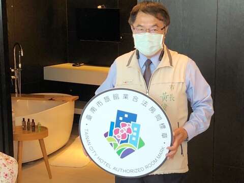 台南市长黄伟哲亲自展示「台南市旅馆业合法房间标章」