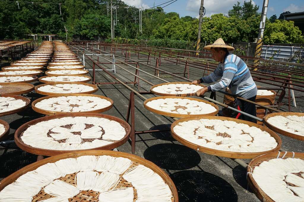 人不时要顾着竹箩筐里的面条