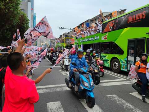 "People wave the flag to welcome the parade team"