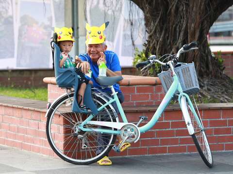 "Grandpa and grandson wear paper hats and have fun"