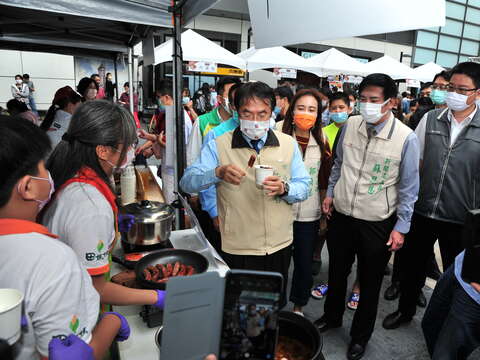 "Mayor Huang Weizhe of Tainan City enjoys the food of the exhibitors"